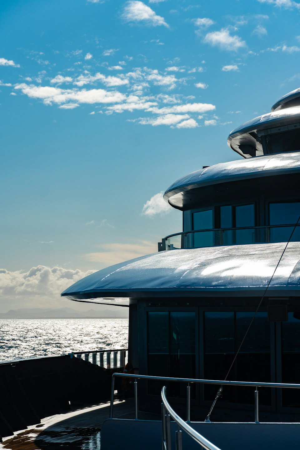Un moderno yacht di lusso color argento naviga su scintillanti acque blu.
