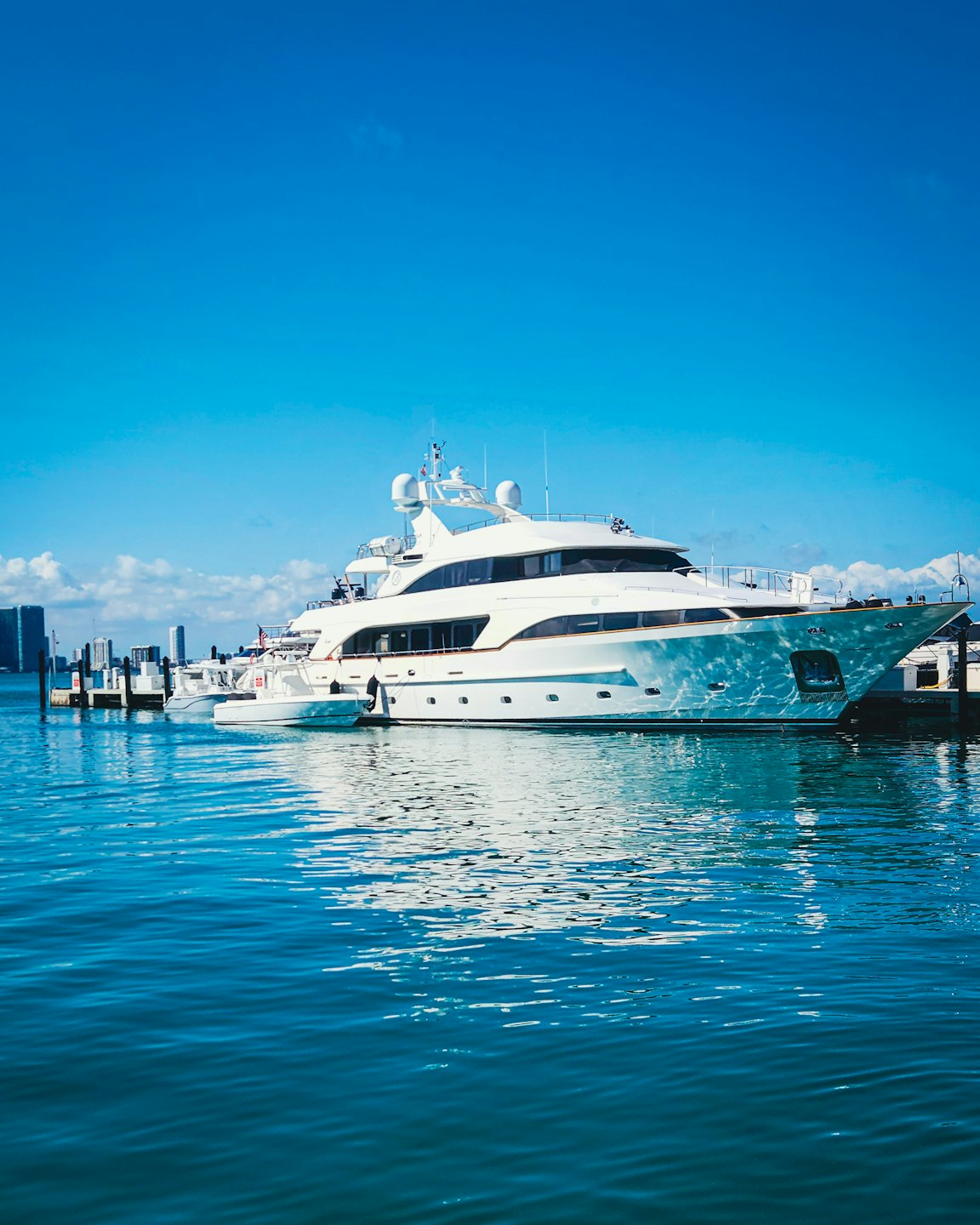 Elegante yacht bianco ormeggiato a un molo del porto in una giornata limpida.